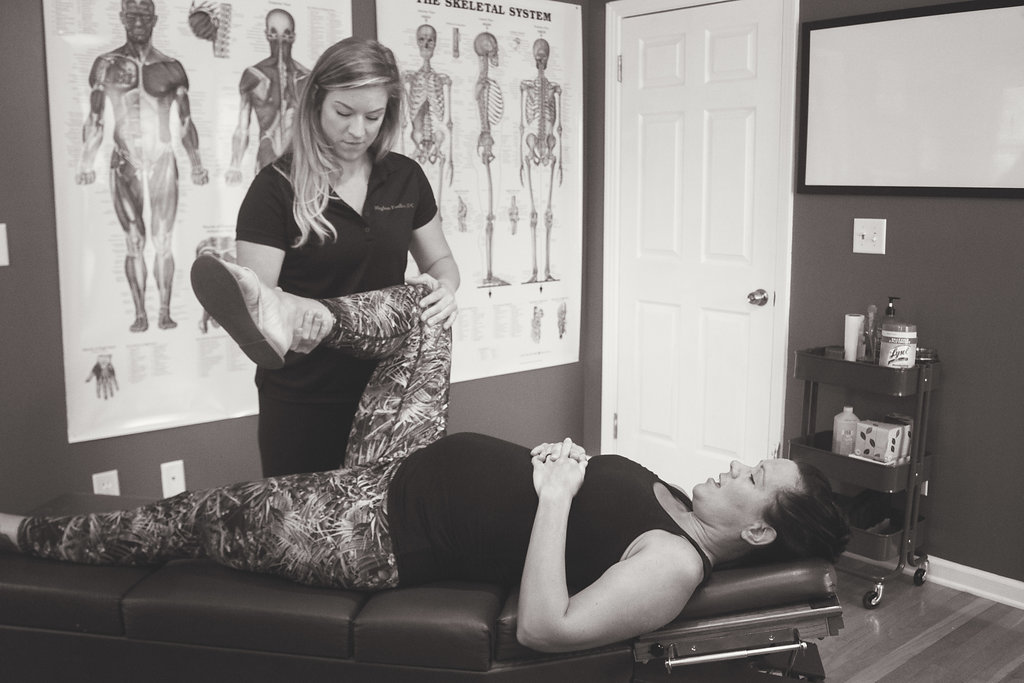 Dr. Meghan Faulkner stretching woman's leg up