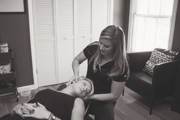 Dr. Meghan Faulkner adjusting blond woman's neck